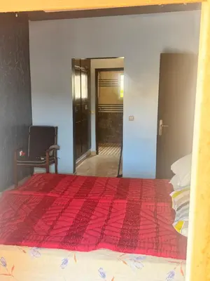 a bedroom with a bed with a red comforter at Petite villa à cap de l eau in Oulad Akkou