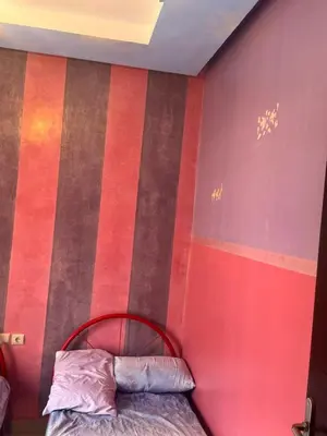 a bedroom with red and brown striped walls and a bed at Petite villa à cap de l eau in Oulad Akkou