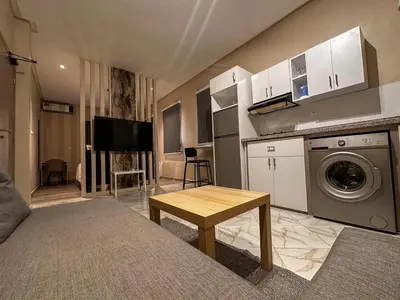 a living room with a kitchen with a washing machine at Relax Family 06 - Cozy Studio in City Center in Ouarzazate