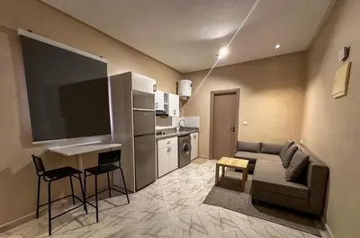 a living room with a couch and a tv and a kitchen at Relax Family 06 - Cozy Studio in City Center in Ouarzazate
