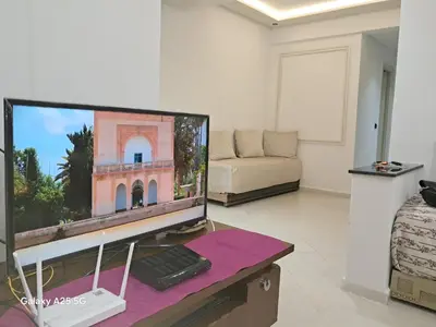 a living room with a computer monitor and a couch at Maison heureuse Vue magnifique très proche autoroute in Meknès