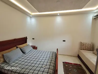 a small bedroom with a bed and a couch at Maison heureuse Vue magnifique très proche autoroute in Meknès