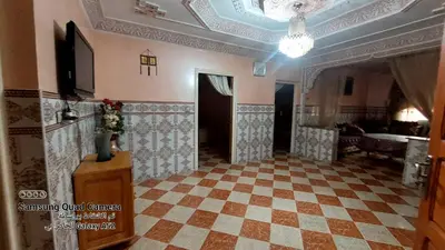 a room with a checkerboard floor and a chandelier at شقق محمد in Oulad Akkou