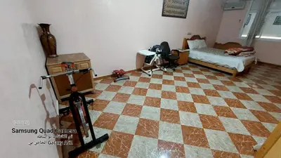 a living room with a checkered floor and a bed at شقق محمد in Oulad Akkou