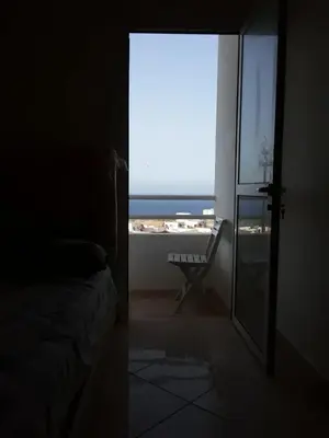 a bedroom with a view of the ocean from a window at Alhoceima in Oulad Akkou