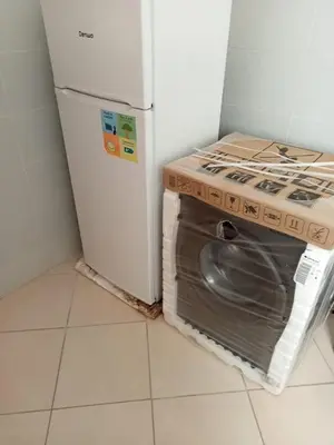 a washer and dryer sitting next to a refrigerator at Alhoceima in Oulad Akkou