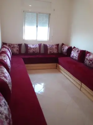 a living room with a red couch and a window at Alhoceima in Oulad Akkou