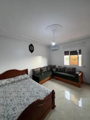 a bedroom with a bed and a couch in it at Résidence badr in Oulad Akkou
