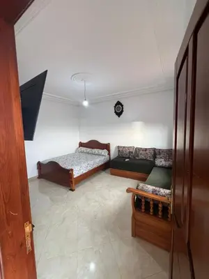 a living room with a couch and a bed at Résidence badr in Oulad Akkou