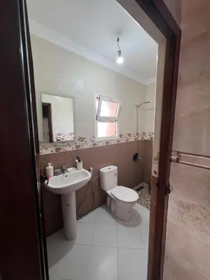a bathroom with a toilet and a sink at Résidence badr in Oulad Akkou