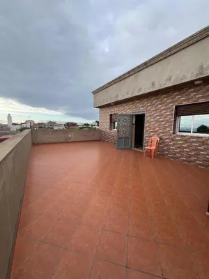 a patio with a chair on top of a building at Résidence badr in Oulad Akkou
