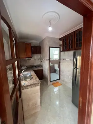 a small kitchen with a sink and a refrigerator at Résidence badr in Oulad Akkou