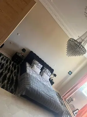 a bedroom with a large bed with white pillows at Palm in Oulad Akkou