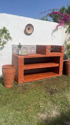 a bench sitting in the grass next to some plants at Palm in Oulad Akkou