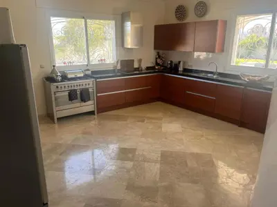 a kitchen with wooden cabinets and a stove at Palm in Oulad Akkou