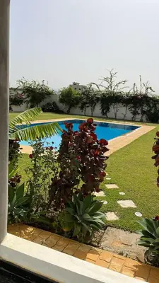 a view of a garden with a swimming pool at Palm in Oulad Akkou