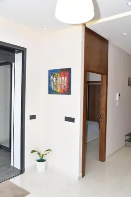 a living room with a painting on the wall at Mehdia Beach in Oulad Akkou
