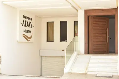 a front door of a house with a sign on it at Mehdia Beach in Oulad Akkou