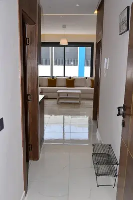 a hallway with a living room with a couch at Mehdia Beach in Oulad Akkou