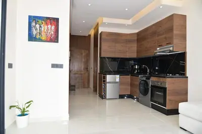 a kitchen with stainless steel appliances and wooden cabinets at Mehdia Beach in Oulad Akkou