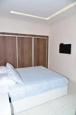 a bedroom with a bed with a tv on the wall at Mehdia Beach in Oulad Akkou