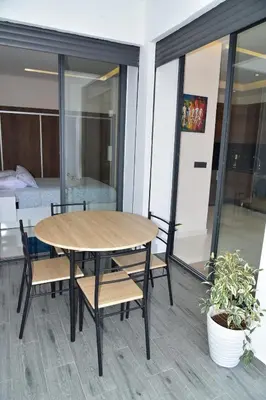 a table and chairs on a balcony with a bedroom at Mehdia Beach in Oulad Akkou