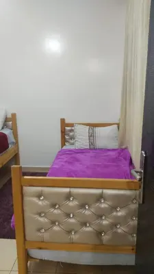 a bed with a purple blanket on top of it at Jardin Ifrane Perle in Oulad Akkou