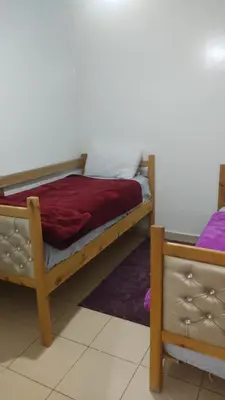 a bedroom with a bed with a red blanket at Jardin Ifrane Perle in Oulad Akkou