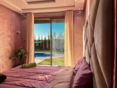 a bedroom with a bed and a large window at Ourika Luxury Villa in Ourika