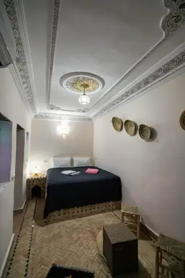 a bedroom with a bed in a room with a ceiling at Riad Fez Unique in Fès