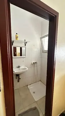 a white bathroom with a sink and a mirror at Elmaghouss in Oulad Akkou