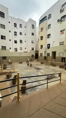 a large building with benches in front of it at Elmaghouss in Oulad Akkou