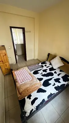 a bedroom with a cow print bed with a mirror at Elmaghouss in Oulad Akkou