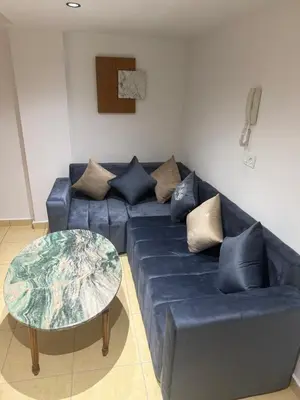 a living room with a blue couch and a table at Descanso ideal en Nador in Oulad Akkou