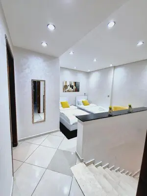 a large room with two beds and a mirror at Bright & Comfortable Marrakech Duplex in Oulad Akkou