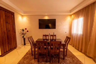 a dining room with a wooden table and chairs at Bright & Comfortable Marrakech Duplex in Oulad Akkou