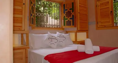 a bedroom with a bed with white pillows and a window at Bab Jbel in Ourika