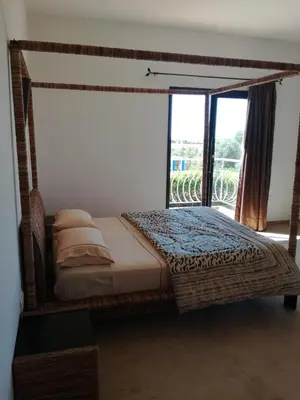 a bedroom with a canopy bed with a large window at Brise de Tamaris in Oulad Akkou