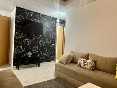 a living room with a couch and a black and white wall at Brise de Tamaris in Oulad Akkou