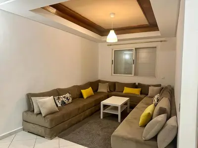 a living room with a brown couch and yellow pillows at Brise de Tamaris in Oulad Akkou