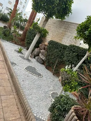 a garden with rocks and trees in a building at Brise de Tamaris in Oulad Akkou