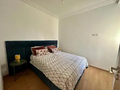 a bedroom with a bed and a table in it at Brise de Tamaris in Oulad Akkou