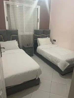 two beds in a hotel room with white sheets at dakhla extreme in Oulad Akkou