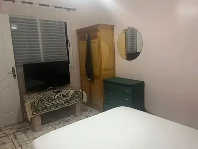 a bedroom with a bed and a dresser and a television at dakhla extreme in Oulad Akkou