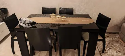 a dining room table with black chairs and a black table with ahibition at Appartement luxe in Oulad Akkou