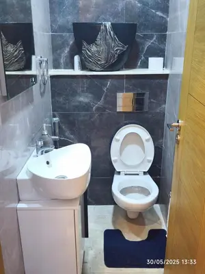 a bathroom with a white toilet and a sink at Appartement luxe in Oulad Akkou