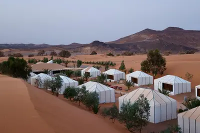 an aerial view of a desert with white tents at Desert Soul Camp in Erfoud