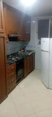 a kitchen with a stove and a refrigerator at La perle de l'Atlas in Oulad Akkou