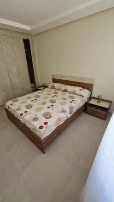 a bedroom with a bed and a table in it at New beachfront apartment in Oulad Akkou
