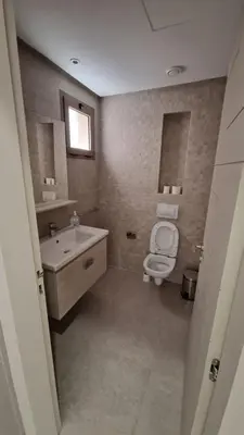 a bathroom with a toilet and a sink and mirror at New beachfront apartment in Oulad Akkou